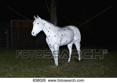 Stock Photograph - Artificial white horse on grass decorated with black dots. Fotosearch