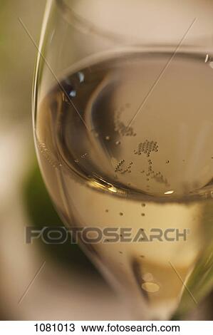 Stock Image - Bubbles in glass of champagne in soft focus. Fotosearch