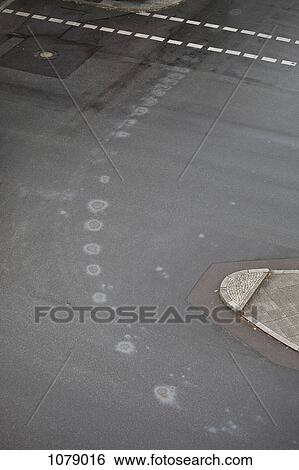 Circular oil stains on a street, high angle view View Large Photo Image Stock Photograph - Circular oil stains on a street, high angle view. Fotosearch