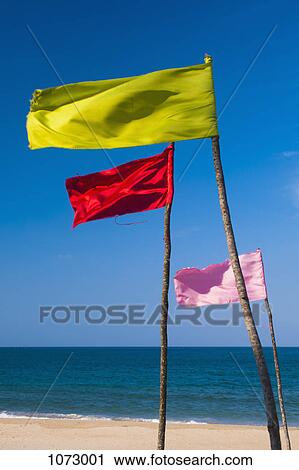 Colored flags flapping in the wind on a beach View Large Photo Image Stock Image - Colored flags flapping in the wind on a beach. Fotosearch
