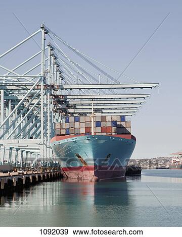 Stock Photo - Container ship preparing for unloading at the docks. Fotosearch