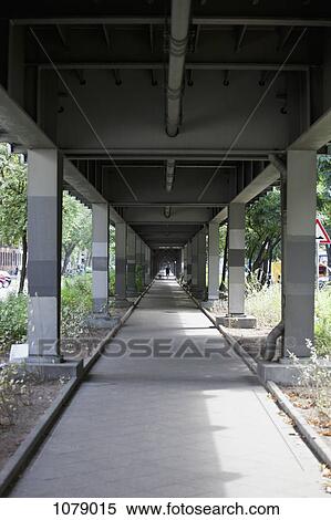 Distant man and dog walking under a railway bridge View Large Photo Image Stock Photography - Distant man and dog walking under a railway bridge. Fotosearch