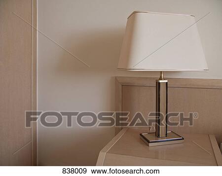 Stock Photo - Hotel lampshade on beige bedside table. Fotosearch