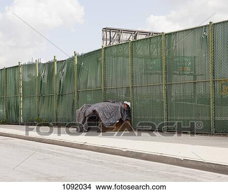 Large wooden box covered in old blankets, beside fence next to road View Large Photo Image Picture - Large wooden box covered in old blankets, beside fence next to road. Fotosearch
