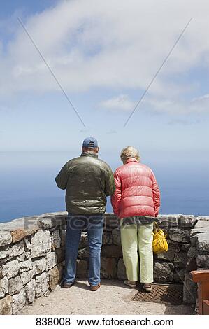 Man and woman peering into sea View Large Photo Image Stock Photo - Man and woman peering into sea. Fotosearch