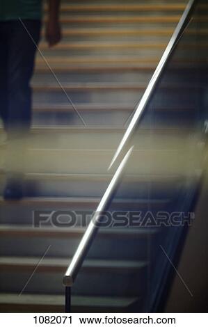 Stock Image - Man walking down stairs. Fotosearch
