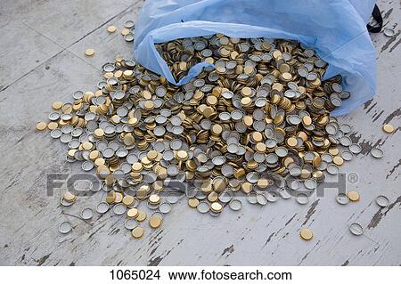 Many bottle caps spilling out of a garbage bag View Large Photo Image Picture - Many bottle caps spilling out of a garbage bag. Fotosearch