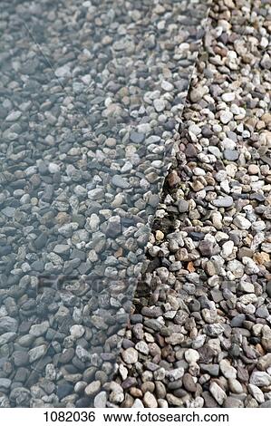 Stock Photograph - Pebbles contrasted by reflection of glass window. Fotosearch
