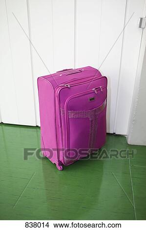 Pink suitcase contrasted against green floor and white door View Large Photo Image Picture - Pink suitcase contrasted against green floor and white door. Fotosearch