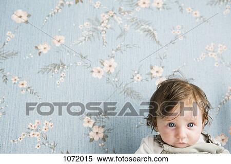 Portrait of a baby in front of floral wallpaper View Large Photo Image Stock Photography - Portrait of a baby in front of floral wallpaper. Fotosearch