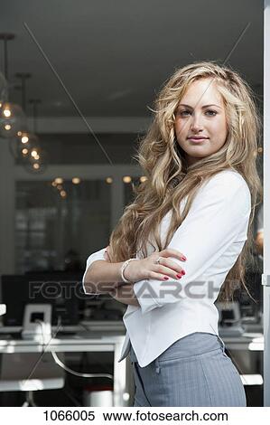 Portrait of a young woman standing in an office View Large Photo Image Stock Photography - Portrait of a young woman standing in an office. Fotosearch