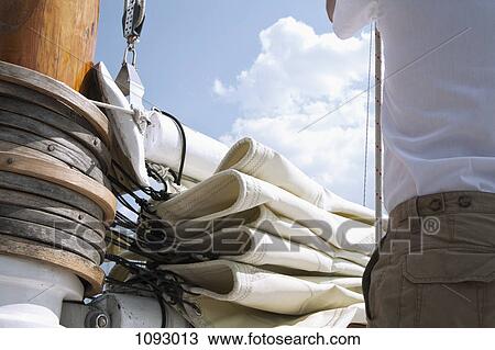 Rear midsection of man next to sail and mast of a passenger sailboat, close-up View Large Photo Image Stock Image - Rear midsection of man next to sail and mast of a passenger sailboat, close-up. Fotosearch