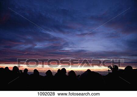 Row of silhouetted people looking at dramatic sky View Large Photo Image Stock Photo - Row of silhouetted people looking at dramatic sky. Fotosearch
