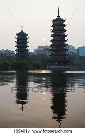 Stock Photo - Sun and Moon Pagodas reflected over Banyan lake. Fotosearch
