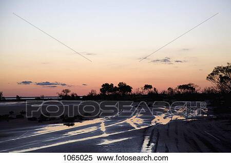 Sun setting on a remote area View Large Photo Image Stock Photography - Sun setting on a remote area. Fotosearch