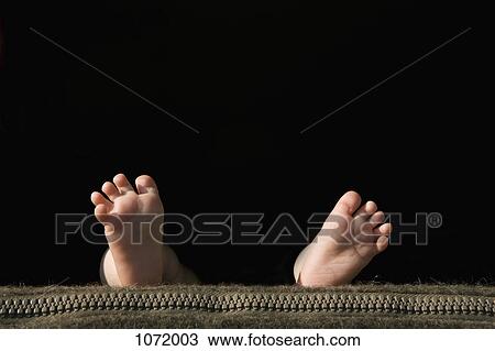 Stock Image - The soles of a baby's feet lying on a pillow. Fotosearch