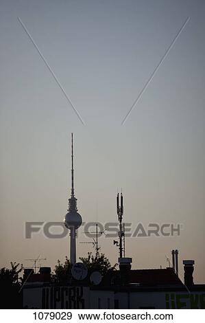 Stock Photo - The TV Tower at Alexanderplatz behind a roof with antennas . Fotosearch