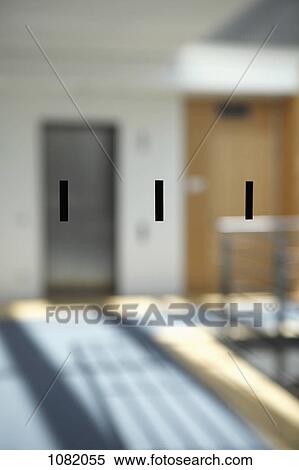 Stock Photography - Three black rectangles on a window pane with office walkway seen in background. Fotosearch