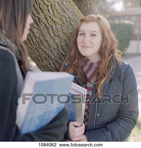 Two female classmates meeting outside class View Large Photo Image Stock Image - Two female classmates meeting outside class. Fotosearch