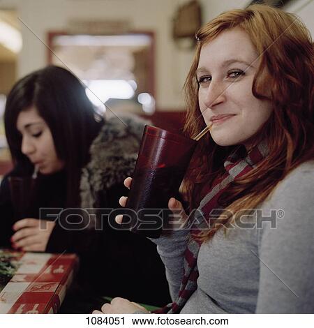 Stock Image - Two young women at a cafe. Fotosearch