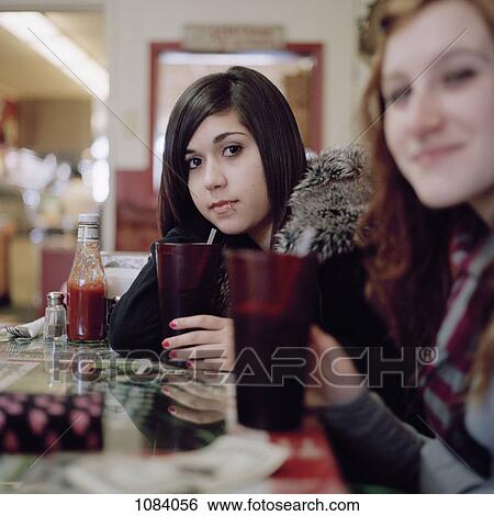Two young women at a cafe View Large Photo Image Stock Photograph - Two young women at a cafe. Fotosearch