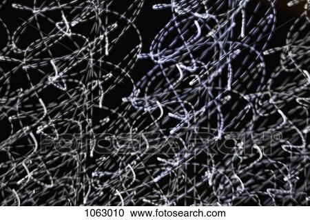Stock Image - White light trails against a black background. Fotosearch
