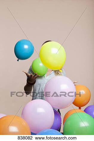 Stock Image - Woman playing with balloons. Fotosearch