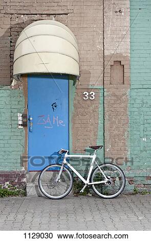A bicycle in front of a rundown building View Large Photo Image Stock Image - A bicycle in front of a rundown building. Fotosearch