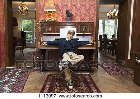 A boy with a cool attitude posing at an old-fashioned upright piano View Large Photo Image Stock Photo - A boy with a cool attitude posing at an old-fashioned upright piano. Fotosearch