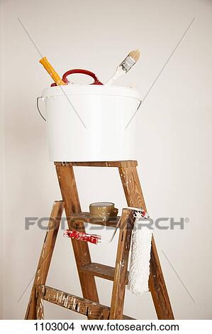A bucket of paint supplies and paint roller on a step ladder, still life View Large Photo Image Picture - A bucket of paint supplies and paint roller on a step ladder, still life. Fotosearch