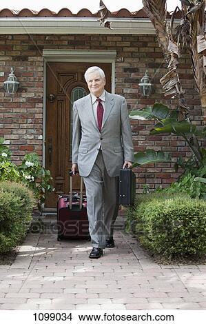 A businessman leaving his home on a business trip View Large Photo Image Picture - A businessman leaving his home on a business trip. Fotosearch