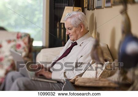 A businessman using a laptop at home View Large Photo Image Stock Image - A businessman using a laptop at home. Fotosearch