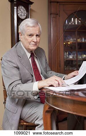 Stock Image - A businessman working at home. Fotosearch