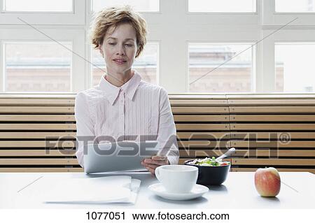A businesswoman using a digital tablet on his lunch break View Large Photo Image Stock Image - A businesswoman using a digital tablet on his lunch break. Fotosearch