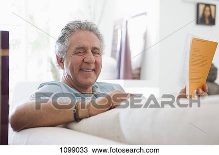 A cheerful senior man reading a book at home View Large Photo Image Stock Image - A cheerful senior man reading a book at home. Fotosearch
