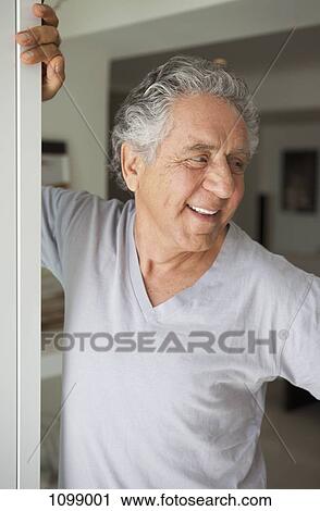 A cheerful senior man standing in a doorway View Large Photo Image Stock Image - A cheerful senior man standing in a doorway. Fotosearch