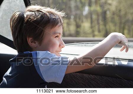 Stock Image - A child looking out a car window. Fotosearch