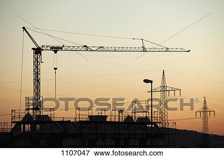 A construction crane and electricity pylons silhouetted against a sunset sky View Large Photo Image Stock Photo - A construction crane and electricity pylons silhouetted against a sunset sky. Fotosearch