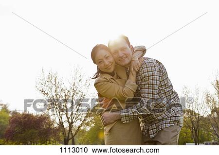 A couple embracing outdoors View Large Photo Image Stock Image - A couple embracing outdoors. Fotosearch