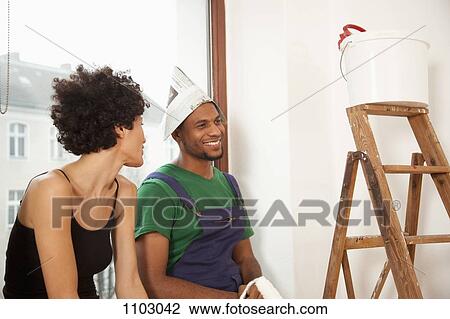 A couple taking a break from painting their apartment View Large Photo Image Stock Image - A couple taking a break from painting their apartment. Fotosearch