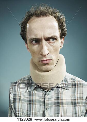 A displeased man wearing a neck brace and looking suspiciously to the side View Large Photo Image Stock Photo - A displeased man wearing a neck brace and looking suspiciously to the side. Fotosearch
