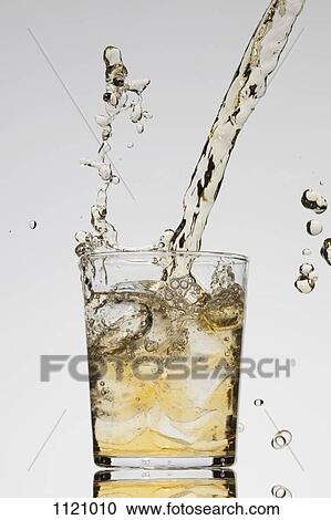 A drink being poured into a glass View Large Photo Image Stock Image - A drink being poured into a glass. Fotosearch