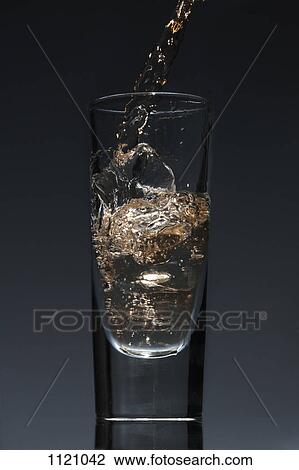 A drink being poured into a glass View Large Photo Image Stock Image - A drink being poured into a glass. Fotosearch