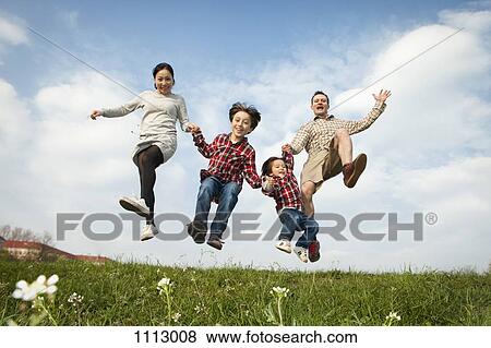 A family holding hands and jumping in the air View Large Photo Image Stock Photo - A family holding hands and jumping in the air. Fotosearch