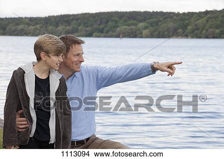 A father pointing something out to his son, outdoors View Large Photo Image Picture - A father pointing something out to his son, outdoors. Fotosearch