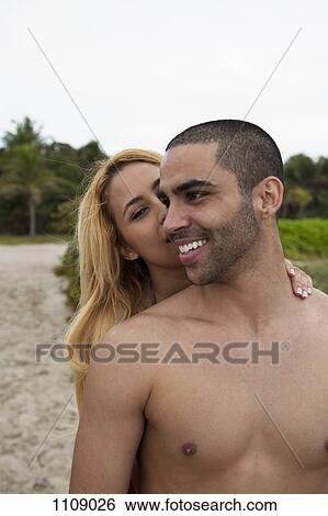 A flirtatious young couple at the beach View Large Photo Image Stock Photograph - A flirtatious young couple at the beach. Fotosearch
