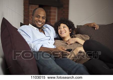A happy laughing couple relaxing on a sofa together View Large Photo Image Stock Photography - A happy laughing couple relaxing on a sofa together. Fotosearch