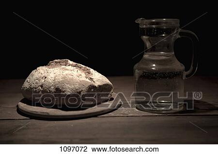 A loaf of bread and a jug of water on a table View Large Photo Image Stock Image - A loaf of bread and a jug of water on a table. Fotosearch