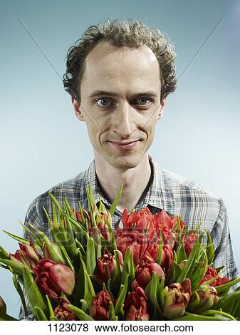 A man holding a bouquet of tulips hopefully View Large Photo Image Stock Photo - A man holding a bouquet of tulips hopefully. Fotosearch