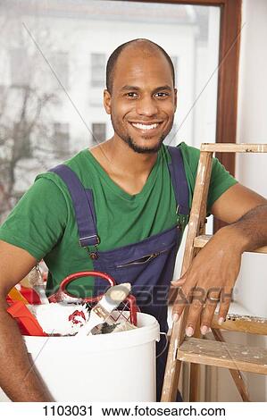 A man holding a bucket of paint supplies leaning on a ladder View Large Photo Image Stock Image - A man holding a bucket of paint supplies leaning on a ladder. Fotosearch